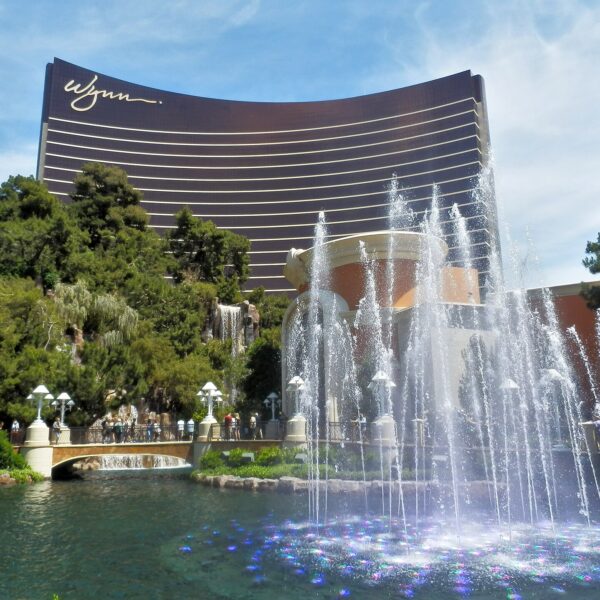 Wynn Las Vegas curved bronze tower behind fountains and trees on a sunny day