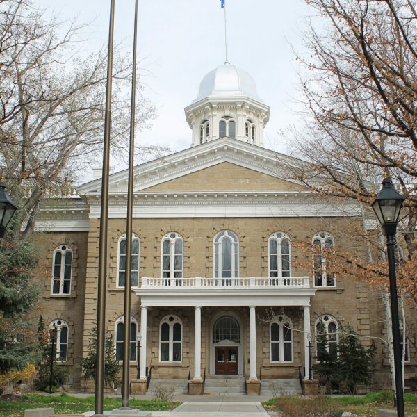 Nevada State Capitol in Carson City with silver dome, flagpoles and leafless trees