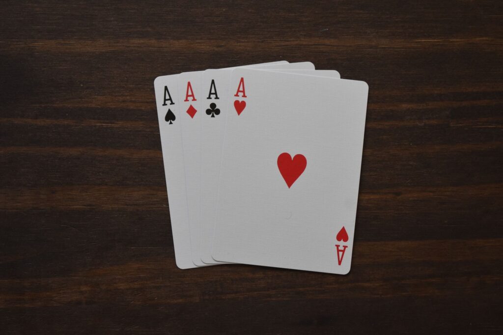 Four aces fanned on a wooden table