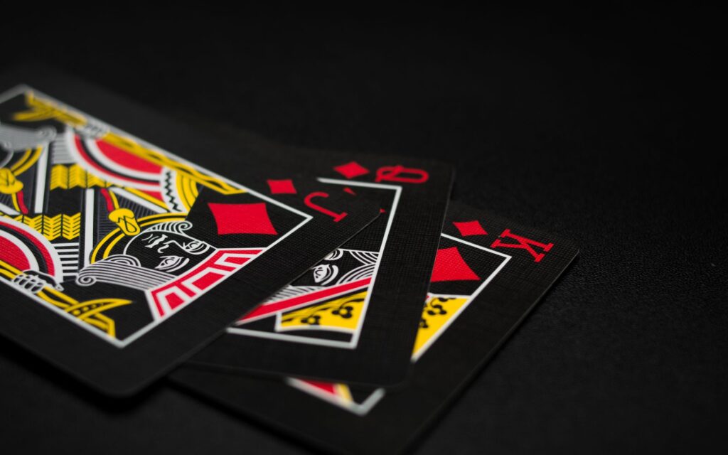 Black and gold playing cards on a dark surface