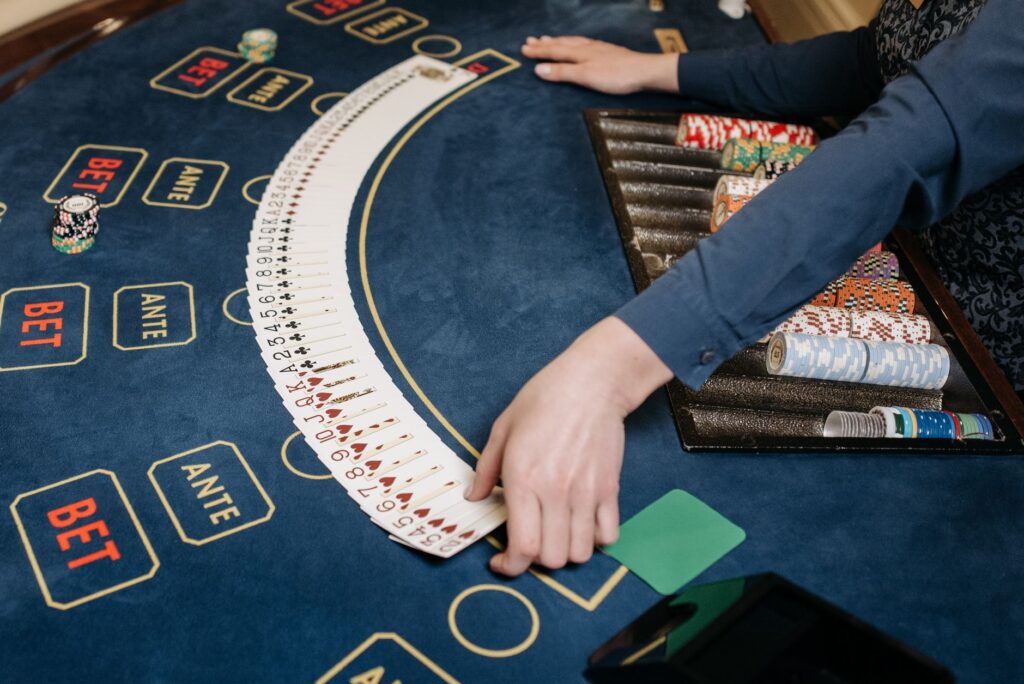Dealer spreading playing cards across a card table
