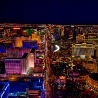 Aerial night view of the Las Vegas Strip lined with brightly lit casino resorts