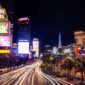 Las Vegas Strip at night with traffic light trails, casino towers and palm-lined boulevard