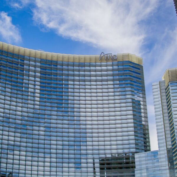 Curved glass tower of Aria Resort and Casino under a blue sky