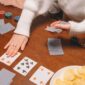 Close-up of a poker game setup with cards and chips on a wooden table, reflecting a cozy indoor activity.