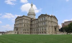 Michigan State Capitol in Lansing with its white dome above a wide green lawn