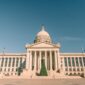 Oklahoma State Capitol with its dome and columned entrance under a clear blue sky