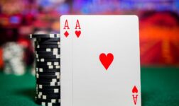 Pair of aces leaning on a stack of black poker chips on a green felt card room table